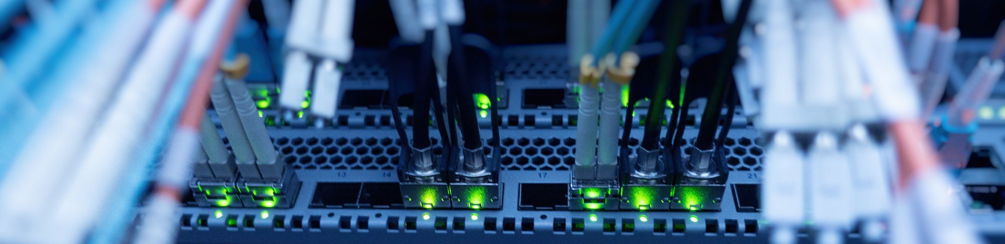 Darstellung von Kabeln die in einem Serverschrank führen und Lichter die blinken.